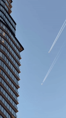 Two jets leave contrails over NYC skyline Saturday night
