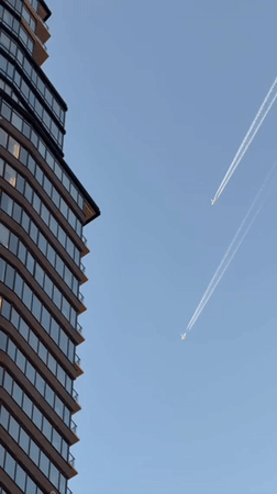 Two jets leave contrails over NYC skyline Saturday night
