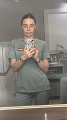 Healthcare worker takes mirror selfie in scrubs