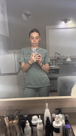 Healthcare worker takes mirror selfie in scrubs