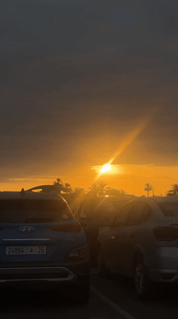 Sunset captured at Marrakesh parking lot amid palm trees