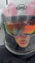 Woman rides motorcycle through Ko Kaeo, Thailand streets