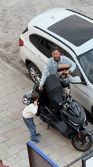 Man with child, scooter observed on Fethiye sidewalk