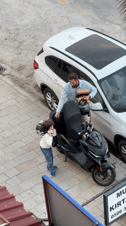 Man with child, scooter observed on Fethiye sidewalk