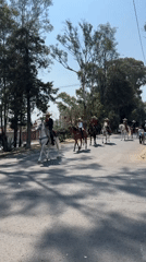 Traditional riders on horseback travel road in Puebla, Mexico