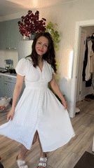Woman in white dress moves through home kitchen in Murino