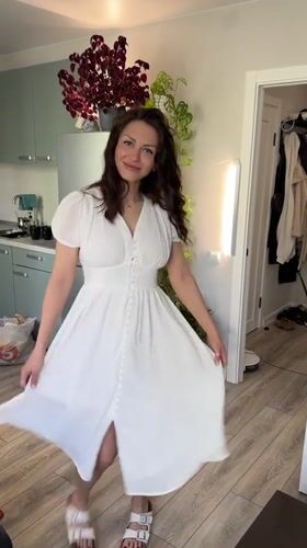Woman in white dress moves through home kitchen in Murino