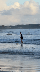 Surfer stands on board in waters off Weligama, Sri Lanka
