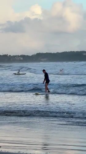 Surfer stands on board in waters off Weligama, Sri Lanka