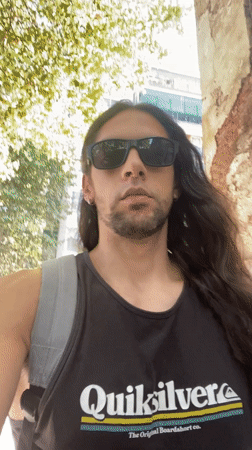 Man films selfie video while walking Buenos Aires sidewalk