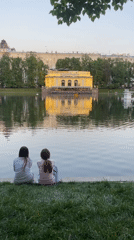 Girls enjoy evening by illuminated waterfront in Moscow