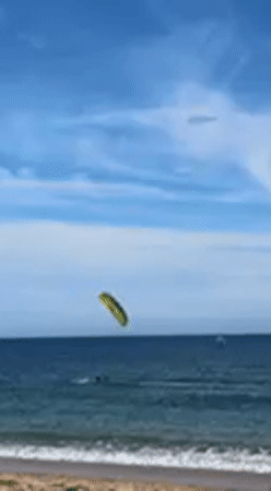 Water sports enthusiast kitesurfs, wing foils off Barbate coast