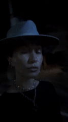 Person in hat and necklaces filmed outdoors in Munggu