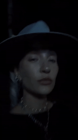 Person in hat and necklaces filmed outdoors in Munggu