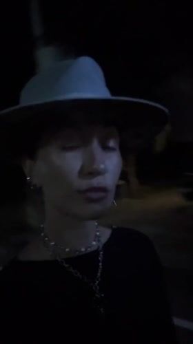 Person in hat and necklaces filmed outdoors in Munggu