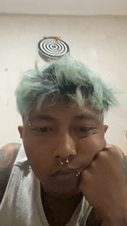 Tattooed individual with green hair photographed in Kuta