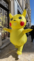 Person in inflatable Pikachu costume walks Marseille sidewalk