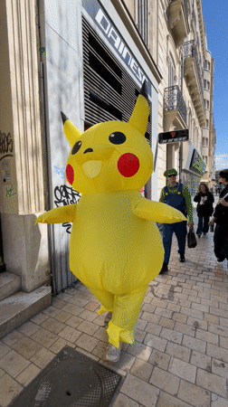 Person in inflatable Pikachu costume walks Marseille sidewalk
