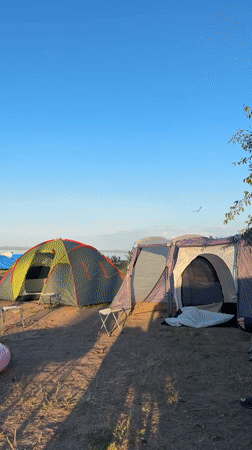 Lakeside campsite in Жемчужный under clear summer skies