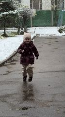 Child plays in unexpected Moscow snowfall during spring morning
