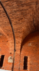 Weathered brick arches and worn walls inside an old structure