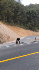 Person works near damaged road section in Da Lat
