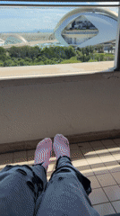 Person rests on Valencia balcony overlooking park and buildings
