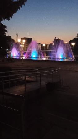 Colorful fountain display illuminates Smila public square at dusk