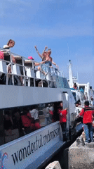 Tourists gather on deck of docked Indonesian tour boat