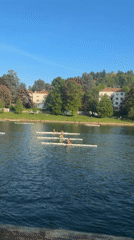 Rowers spotted on Turin river under clear skies