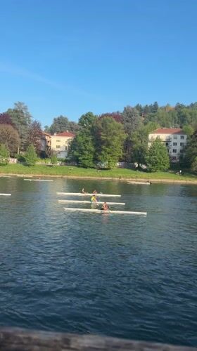 Rowers spotted on Turin river under clear skies