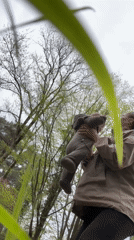 Woman holds baby outdoors in Sochi park area