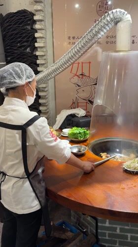 Chef prepares hot pot dishes at Wulingyuan restaurant