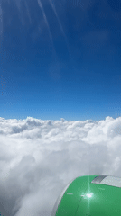 Aerial view captures clouds and sunlight from airplane window