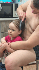 Father brushes daughter's hair in Chaikovsky kitchen