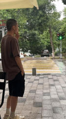 Young man observed smoking, watching street in Tashkent