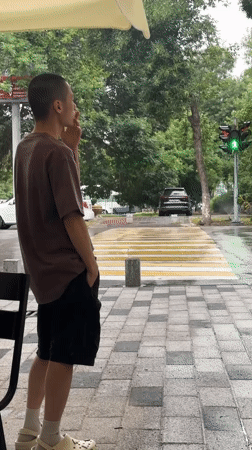 Young man observed smoking, watching street in Tashkent