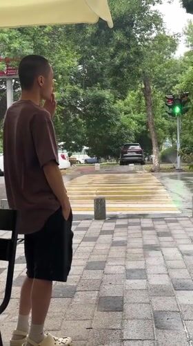 Young man observed smoking, watching street in Tashkent