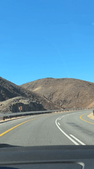 Vehicle travels desert mountain road in South Africa