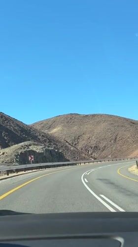 Vehicle travels desert mountain road in South Africa