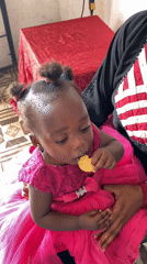 Child in pink dress photographed with adult in Vom, Nigeria
