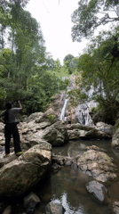 Tourists photograph tropical waterfall in Ko Samui jungle setting