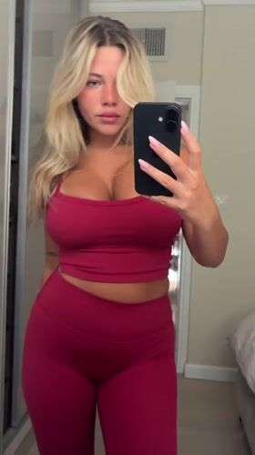Woman takes mirror selfie in red outfit in Eilat