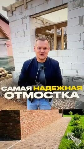 A man in a blue jacket and jeans stands in front of a partially constructed building. He gestures and speaks to the camera, with text overlaying the video. The video then transitions to show close-ups of cracked and broken concrete around the foundation of a building, followed by a shot of damaged brickwork and a crumbling foundation. The final shot returns to the man, who is now wearing gloves and appears to be starting a task, with text indicating he will explain something. The overall theme appears to be about building a reliable foundation or blind area for a house.
