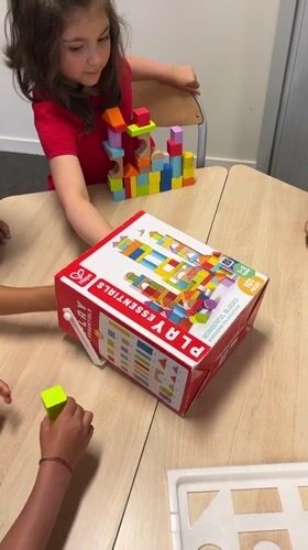 Kids build block towers and do coloring at a table in La Fouillouse
