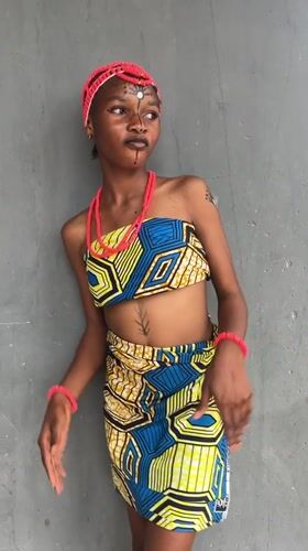 Woman poses in traditional African dress in Badagry