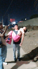 Man carries person on Porlamar sidewalk while being filmed