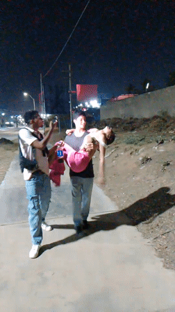 Man carries person on Porlamar sidewalk while being filmed