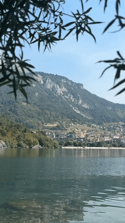 Seaplane cuts across a still Alpine lake on a clear morning