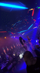 Nightclub scene with dancing, neon lights, and bar crowd